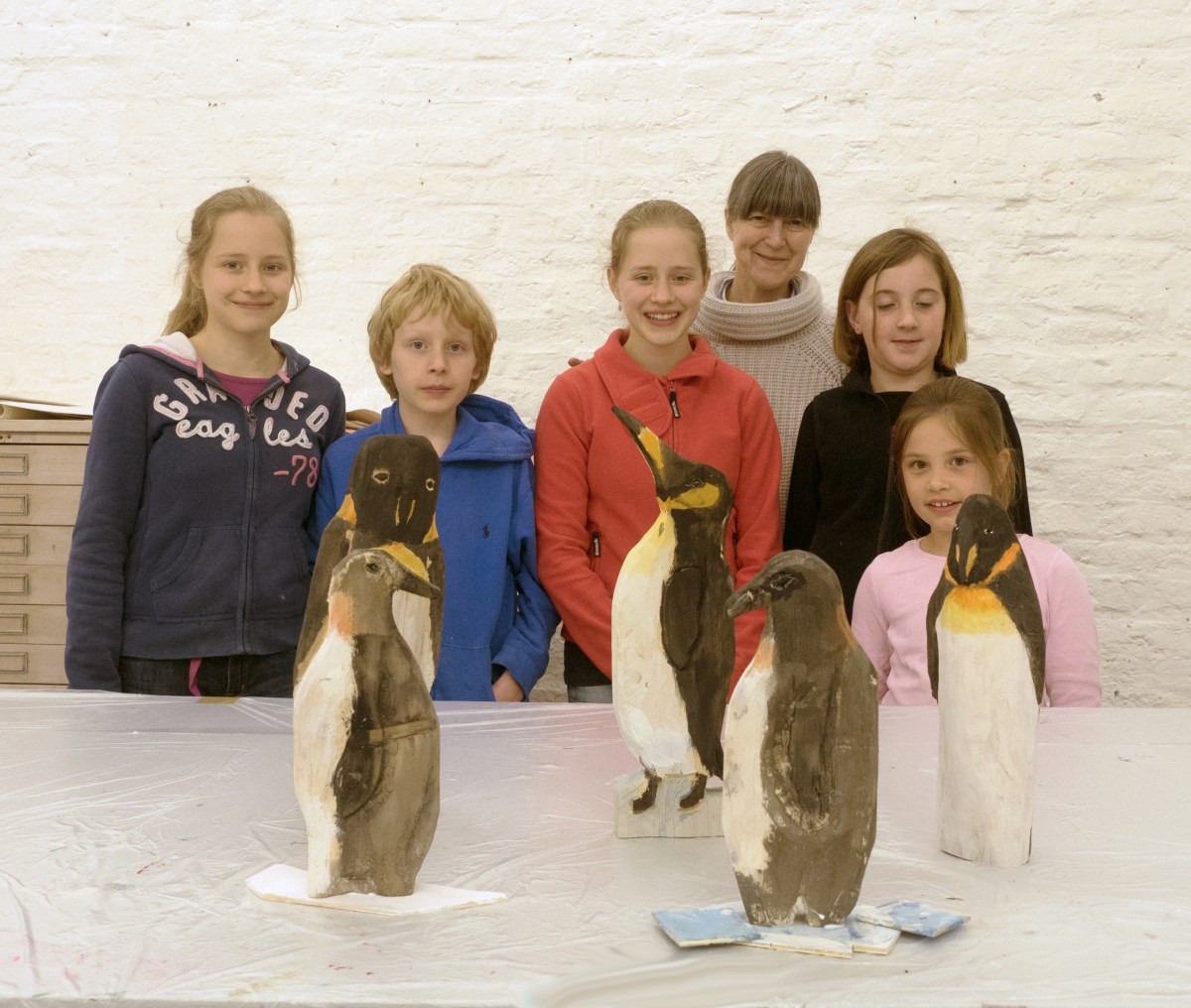 Die Schüler zeigen stolz ihre Werke in Begleitung von Gabriele Enss.